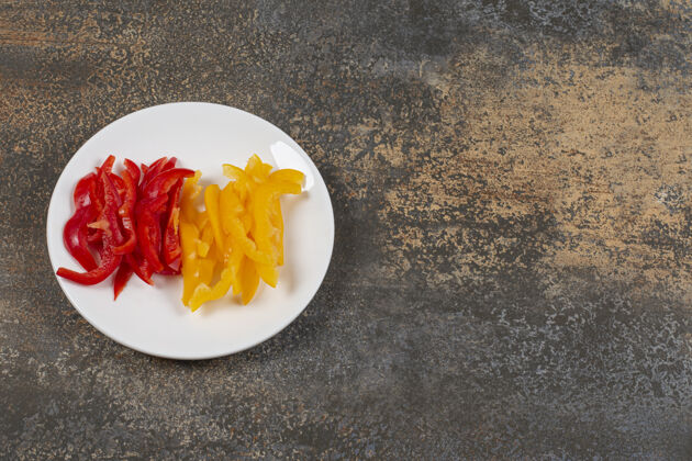 天然一套红黄辣椒片放在白盘子里铃铛切片有机