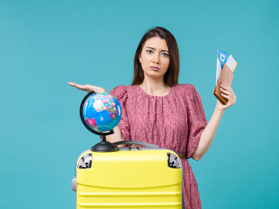 票前视图度假中的女性拿着她的钱包和机票在淡蓝色的背景海上旅行度假女性旅行旅行旅行光