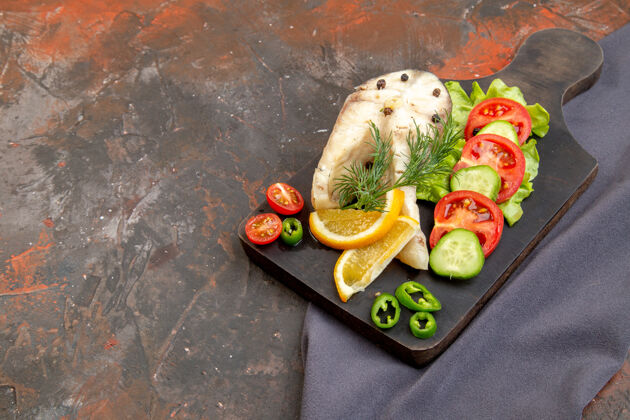 餐厅在混合色表面上的深色毛巾上的黑色切割板上的生鱼和胡椒新鲜食物的侧视图寿司切割混合