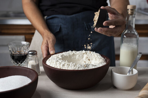 健康一个装满面粉的碗的特写镜头 一个人在里面倒配料糕点厨房面粉