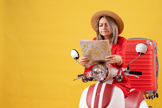 地图前视图忙碌的漂亮女孩骑着轻便摩托车和红色手提箱看地图轻便摩托车人人