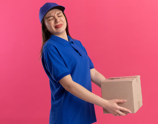 制服穿着制服的未出租的漂亮送货员手里拿着粉红色的沉重名片盒粉色女人沉重