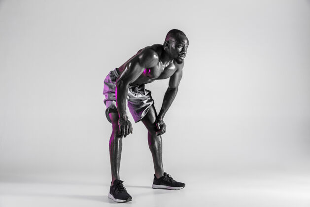 休息无所畏惧在灰色背景下拍摄的年轻非裔美国健美运动员训练的摄影棚镜头穿着运动服站立的肌肉发达的单身男模运动 健美 健活方式的概念赛车健身健美