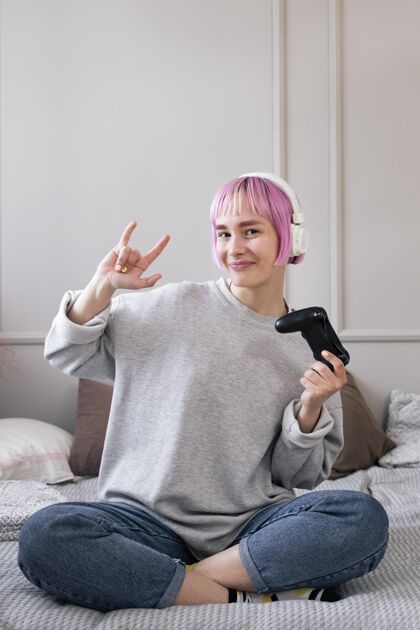 乐趣粉红色头发的女人在玩电子游戏享受游戏技术
