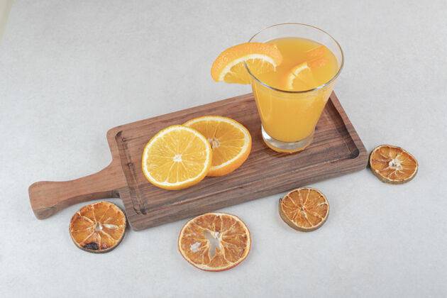 提神一杯果汁和橘子片放在木板上柑橘美味新鲜