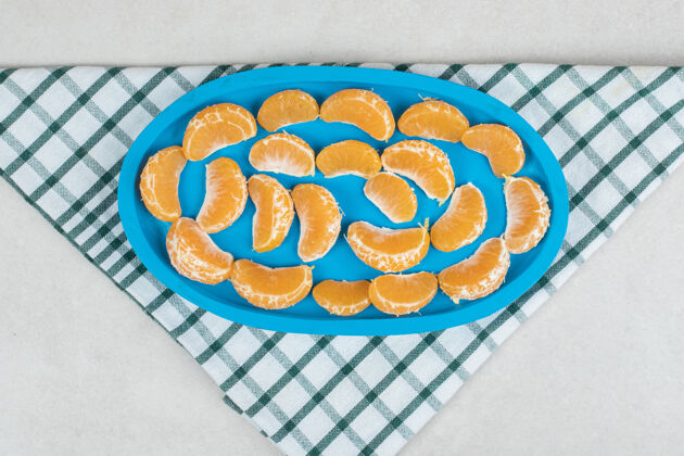 美味蓝色盘子上有多汁的橘子片柑橘配料新鲜