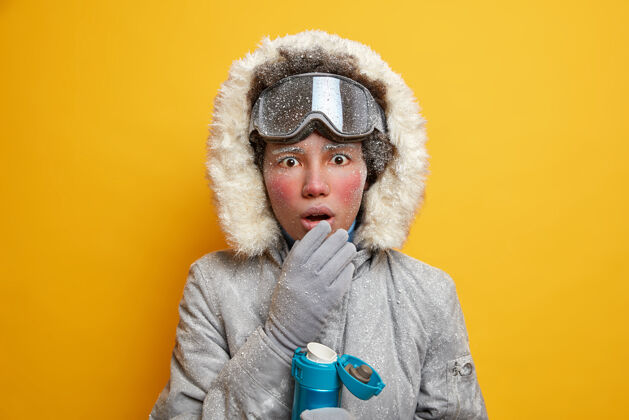 霜冻寒假概念惊讶的民族活跃的女人喜欢运动活动保持嘴巴张开从休克饮料热饮料穿着外套休息手套天气