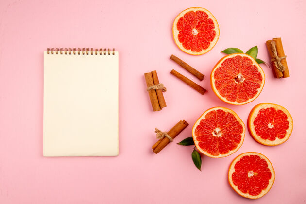 纸张美味的葡萄柚水果切片与肉桂粉红表面俯视图新鲜醇香柑橘