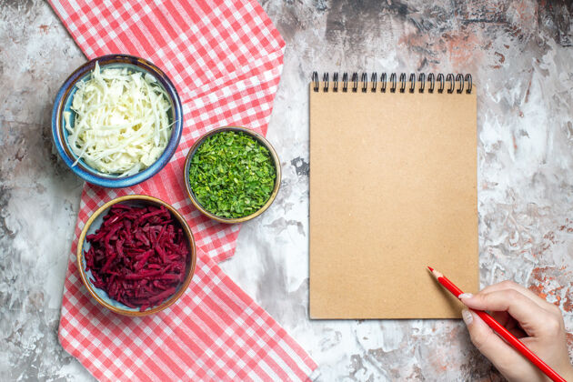 胡椒粉白色表面上的甜菜和绿色切片卷心菜俯视图切片白菜健康午餐