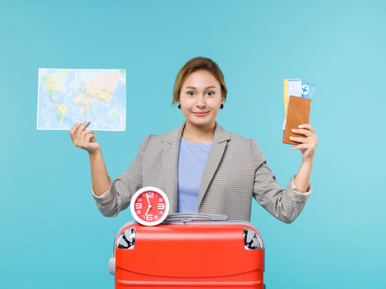 航行正面图：度假中的女性手持蓝色背景的地图和机票 远航出海度假票微笑人