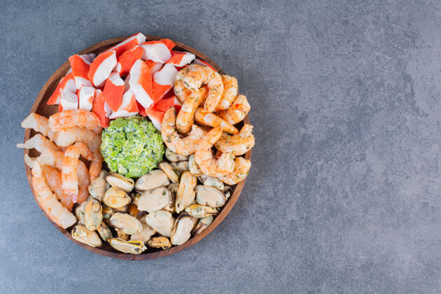 新鲜一盘美味的虾和美味的蟹棒放在石头表面美味饮食小吃