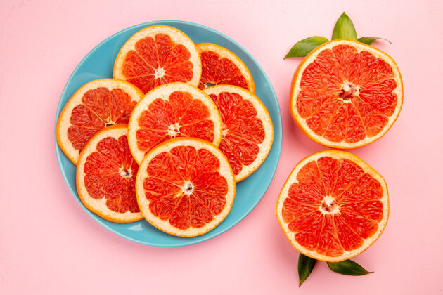 柑橘美味的葡萄柚水果片在粉红色表面盘子内俯视图盘子饮食切片