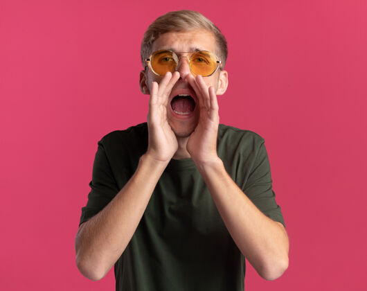 某人年轻帅哥 穿着绿色衬衫 戴着眼镜 看着前面 在粉红色的墙上叫着一个孤立的人帅哥人站