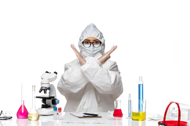 女化学家前视图穿着特殊防护服的女化学家在白色背景上显示禁止标志-化学病毒实验室专业医学病毒