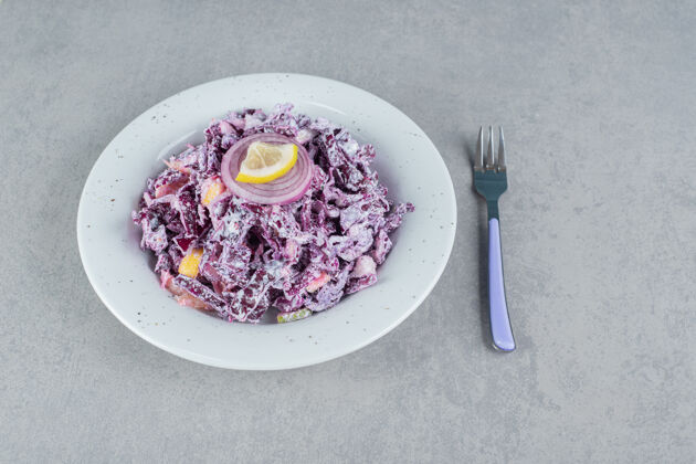 盘子紫色卷心菜和洋葱沙拉放在白色陶瓷盘子里餐具早午餐剁碎