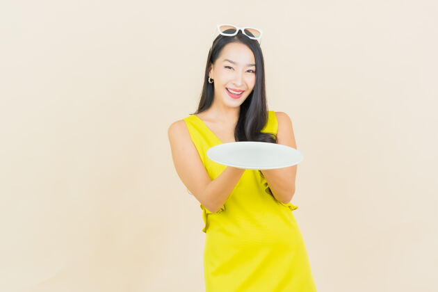 亚洲画像美丽的亚洲年轻女子微笑着在彩色墙上的空盘子乐趣喜悦厨师