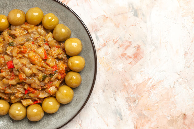 食品烤茄子沙拉和腌李子在裸体表面上的盘子俯视图盘子饮食蔬菜