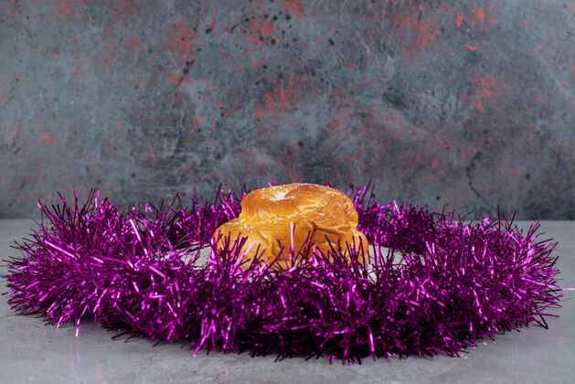 金箔在大理石桌上的一个小面包周围有一圈紫色的金属丝辛辣甜点糕点