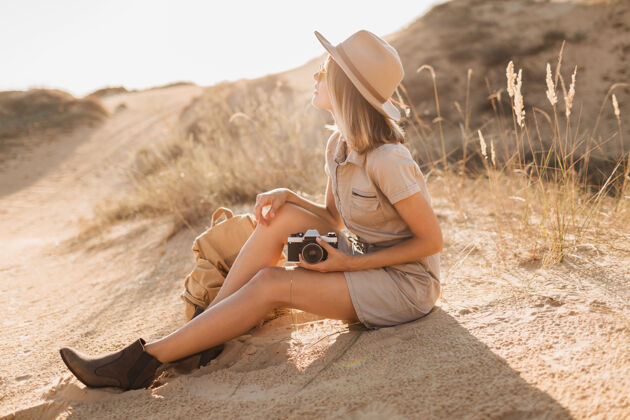 体验沙漠中穿着卡其色长裙 戴着帽子和背包 在非洲旅行的迷人时尚年轻女子背包夏天阳光