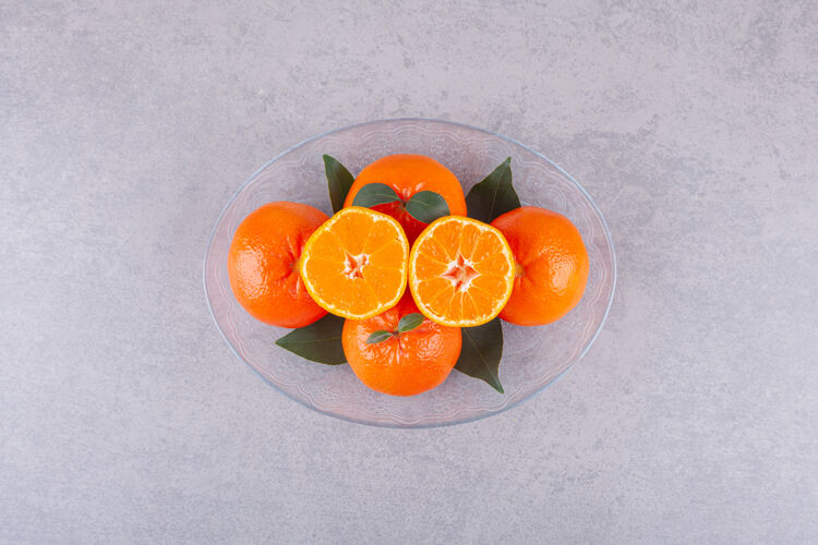 甜点把整个橘子和切成片的橘子放在石头表面上切半水果