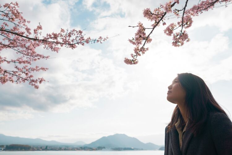 开花亚洲女人欣赏她周围的大自然日本开花花