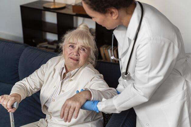 保健医生帮助她的老病人站起来医生健康问题医疗