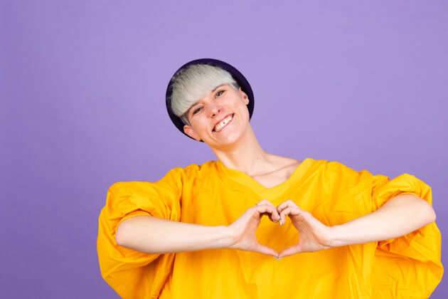 情人节紫色墙上的时髦欧洲女人衣服站立快乐