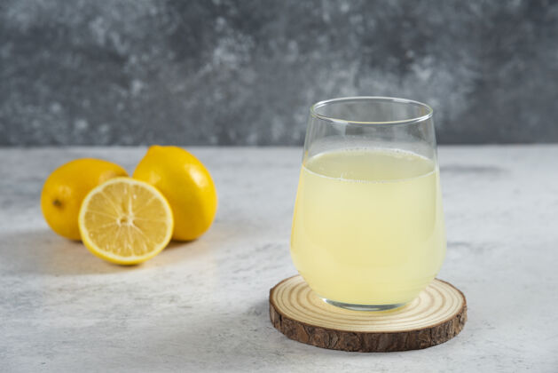 冷在木板上放一杯新鲜的柠檬汁柠檬切片杯子