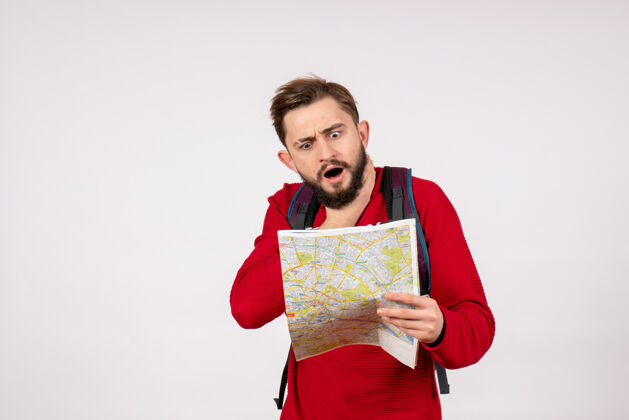 情感正面图年轻男性游客背着背包探索地图白墙飞机城市度假情感人文旅游线路人游客背包