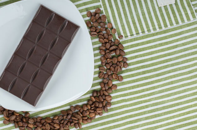 棒在桌布上放一块巧克力和咖啡豆豆美味营养