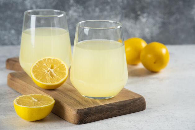 液体在木板上放两杯美味的柠檬水凉的可口的冷的