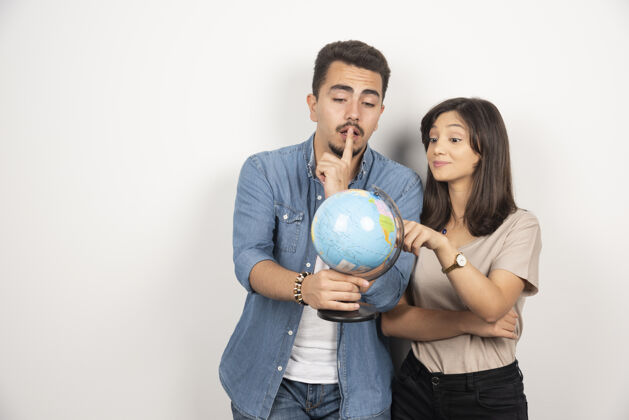 男人拿着地球仪的年轻夫妇的画像女人地球女人