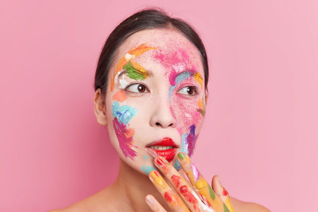 脸体贴美丽的亚洲女人涂上明亮的水彩画作品艺术家赤膊上阵隔离粉红色背景颜色水彩画立场