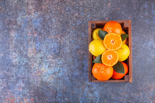 成熟新鲜的柑橘类水果 叶子放在一个旧木箱里柑橘味道美味