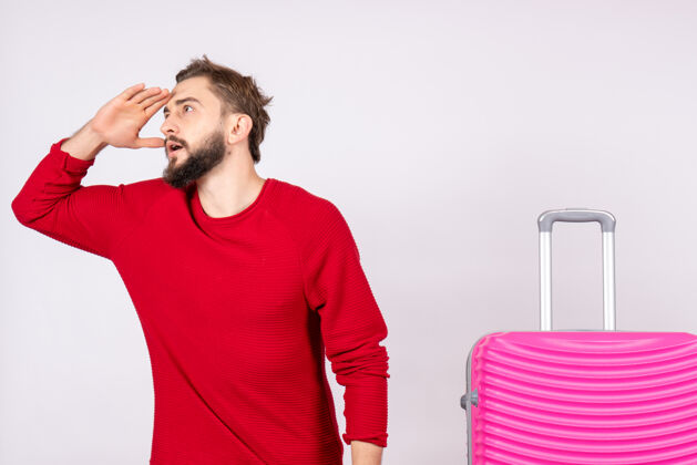 成年人正面图白色墙壁上带着粉色包的年轻男性旅行照人色度假飞行航行夏季肖像男人年轻男性