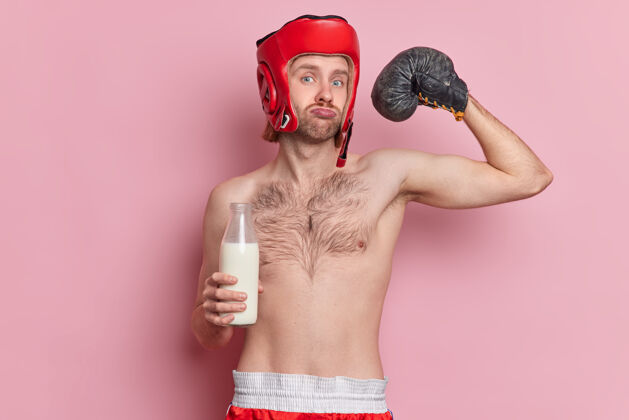 瓶子严肃的男拳击手举起手臂展示肌肉展示他的力量直视镜头喝牛奶白种人力量健康