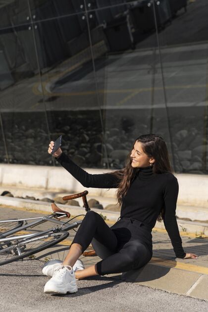 环保在自行车旁自拍的女人城市户外骑行
