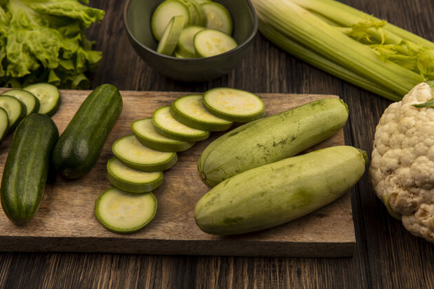 饮食顶视图新鲜切碎的黄瓜和西葫芦孤立在一个木制的厨房板与莴苣芹菜和花椰菜孤立在一个木制的背景生菜芹菜西葫芦