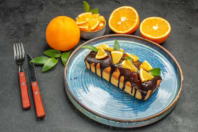 餐厅一套黄色全切橙子的侧视图用刀叉做的美味蛋糕刀整个餐