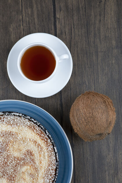烘焙一盘美味的派和新鲜的整个椰子放在木桌上面包房椰子整个