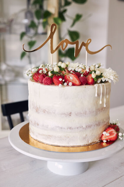 蛋糕精选焦点拍摄美味的白色婚礼蛋糕与红色浆果 鲜花和蛋糕顶自制糕点美食