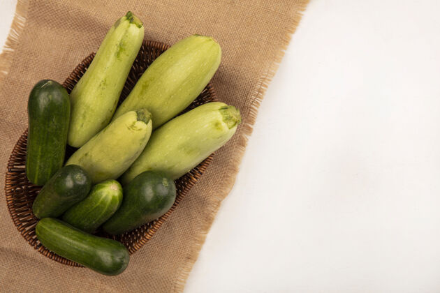 健康健康绿色蔬菜的俯视图 如黄瓜西葫芦 放在一个桶上 布袋上 白色背景 留有复印空间复制衣服西葫芦