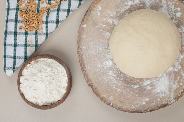 面包房在木板上放一碗面粉和面团烘焙生的堆
