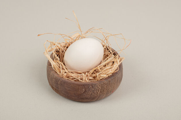 木材木碗里放着新鲜的鸡蛋和干草鸡蛋干草蛋白质