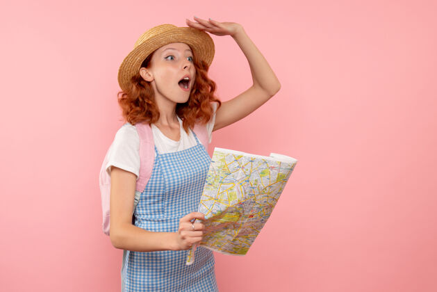 时尚女游客正拿着地图在外国寻找方向旅行女人粉色