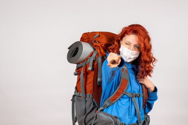 女人正面图戴面具的女游客带着她的背包肖像旅行猎人
