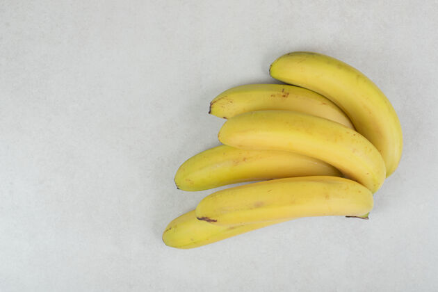 热带一堆黄色的香蕉在灰色的表面上新鲜有机水果