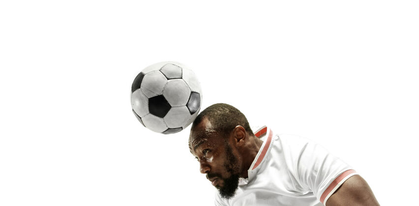 运动装一个情绪激动的男人踢足球的特写镜头 他的头撞在孤立的白墙上人球头球