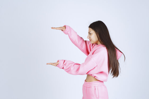测量穿着粉色睡衣的女孩 展示产品的估计数量或尺寸姿势尺寸女人