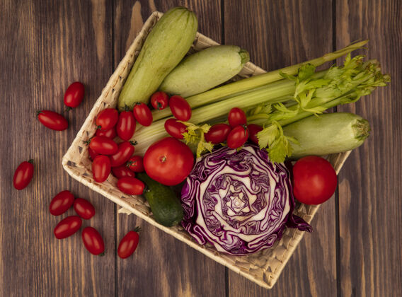 新鲜顶视图新鲜蔬菜 如西红柿 芹菜 紫色卷心菜和西葫芦在木桶上的背景蔬菜观点西葫芦